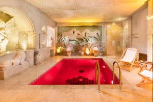 a large red bath tub in a room at Oba Cave Hotel in Urgup