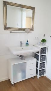 a bathroom with a white sink and a mirror at Ferienwohnung Trave - Wohlfühlatmosphäre zum Auftanken in Bad Oldesloe