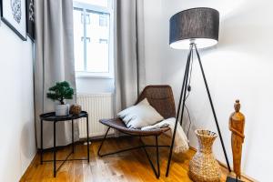 soggiorno con sedia e lampada da pavimento di Stylish designed apartment in a calm district a Vienna