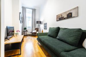 sala de estar con sofá verde y mesa en Stylish designed apartment in a calm district en Viena