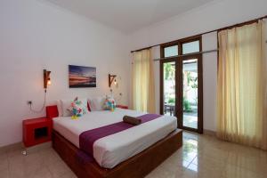 Postel nebo postele na pokoji v ubytování Kidi's Lodge Gilitrawangan