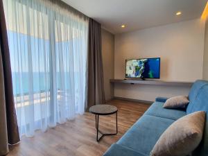 a living room with a blue couch and a tv at LOOKOUT Apartments in Sarandë
