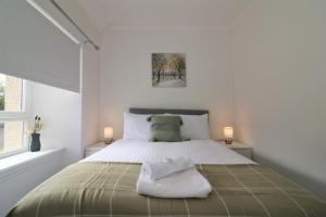 1 dormitorio blanco con 1 cama grande y 2 lámparas en Signature - Kirkhill Middle, en Kirkmuirhill