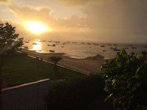 雷日卡普费雷Entre dune et plage Les Jacquets Cap Ferret的海滩上的日落,在水中划船