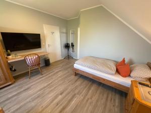 a room with a bed and a desk and a television at Hotel St. Peter in Dormagen