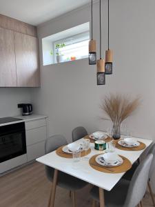 cocina con mesa blanca con sillas y comedor en Kastani Apartments en Rakvere