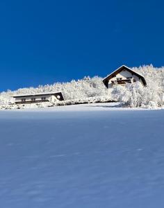 una casa sentada en la cima de un campo cubierto de nieve en Nocky Mountains Lodge, en Radenthein