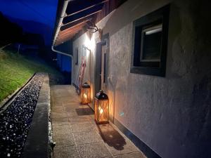 Deux lumières sur le côté d'un bâtiment la nuit dans l'établissement Nocky Mountains Lodge, à Radenthein
