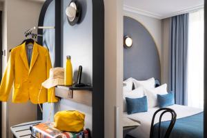 a hotel room with a bed and a yellow coat at Hôtel de France Gare de Lyon Bastille in Paris