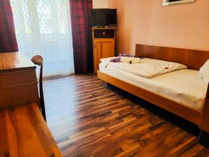 een slaapkamer met een bed en een houten vloer bij City Hotel Pforzheim in Pforzheim