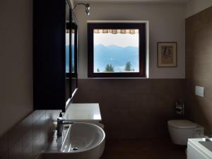 a bathroom with a sink and a toilet and a window at Amazing 3 bedrooms villa with lavish garden, breathtaking lake and mountains view in Luino
