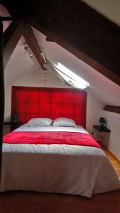 a large bed with a red headboard in a room at 50 M OCÉAN maison classée 2 étoiles 2/7 personnes in Mimizan