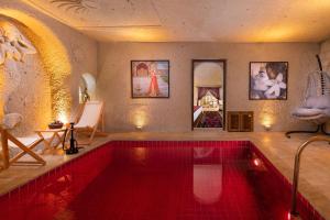 a swimming pool with a red tiled floor and a room at Oba Cave Hotel in Urgup