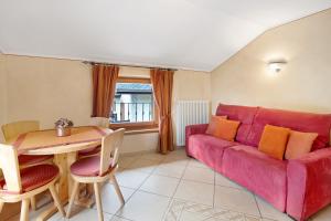 een woonkamer met een rode bank en een tafel bij Baita Aris Appartamento Ables in Livigno