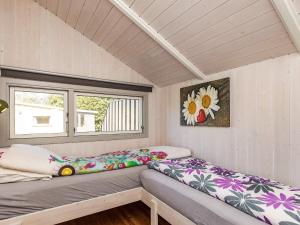 オテルプにあるHoliday home Otterupのベッドと窓が備わる小さな客室です。
