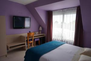 1 dormitorio con 1 cama, escritorio y TV en Hotel Ker Vennaik, en Bénodet