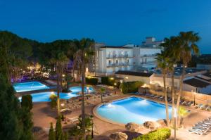 eine Luftansicht eines Resortpools in der Nacht in der Unterkunft Hotel Castell dels Hams in Porto Cristo