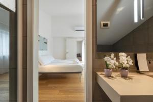 um quarto com uma cama e um espelho em HEART OF TRENTO Loft & Rooms em Trento