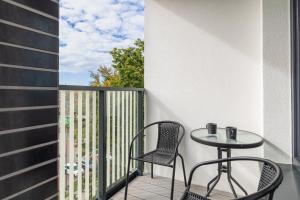 a balcony with two chairs and a table at Apartments Nad Parsętą Młyńska by Renters in Kołobrzeg