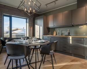 cocina con mesa y sillas y cocina con ventana en Riddertunet apartment 101, en Beitostølen