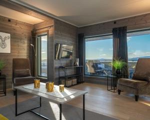 贝特斯托尔Riddertunet apartment 101的客厅配有桌椅和大窗户