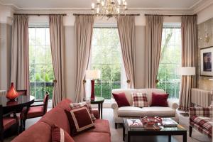- un salon avec un canapé, des chaises et des fenêtres dans l'établissement The Goodenough Hotel London, à Londres
