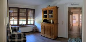 a living room with a wooden cabinet and a window at Hof Helmenhube 1 in Gammelsbach