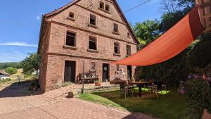 un viejo edificio de ladrillo con una mesa delante en Hof Helmenhube 1, en Gammelsbach