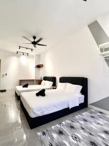 2 Betten in einem Schlafzimmer mit Deckenventilator in der Unterkunft Imperio Residences Private Bathtub or Jacuzzi by Nestcove in Malakka