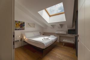 um quarto com uma cama e uma clarabóia em HEART OF TRENTO Loft & Rooms em Trento