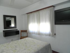 a bedroom with a bed and a window with a television at Hotel Adriatico in Mar del Plata