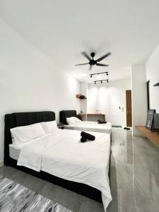 a bedroom with two beds and a ceiling fan at Imperio Residences Private Bathtub or Jacuzzi by Nestcove in Melaka