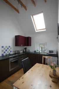 a kitchen with a wooden table and a skylight at Macleod Cottage - Isle of Lewis Self-Catering in Port of Ness