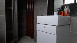a bathroom with a white sink and a shower at Limbila House in Cape Town +34 photos