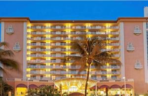 un gran hotel con una palmera delante de él en MIAMI APARTMENT RENTAL en Miami Beach