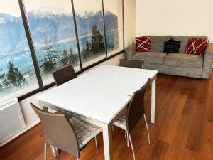 een witte tafel en stoelen in een kamer met een groot raam bij Appartement en plein cœur d'Aix-les-Bains in Aix-les-Bains