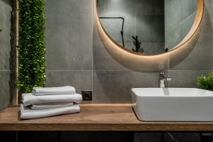 a bathroom with a sink and a mirror and towels at CUTE Apartment Šiauliai FREE Parking in Šiauliai