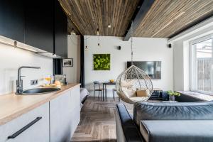 eine Küche und ein Wohnzimmer mit einem Sofa und einem Tisch in der Unterkunft CUTE Siauliai townhouse with terrace in Šiauliai