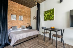 um quarto com uma cama, uma mesa e uma parede de tijolos em CUTE Siauliai townhouse with terrace em Siauliai