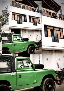 einem grünen Auto, das vor einem Gebäude parkt in der Unterkunft Amuya Hostel in Chiquinquirá