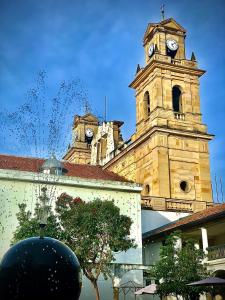 um edifício antigo com uma torre de relógio ao fundo em Amuya Hostel em Chiquinquirá