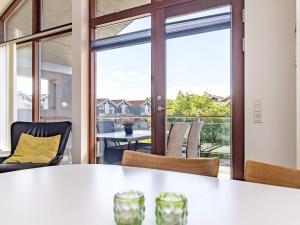 ボーゲンセにある4 person holiday home in Bogenseのテーブルと椅子、大きな窓が備わる客室です。