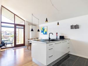 a white kitchen with a sink and a table at 4 person holiday home in Bogense in Bogense