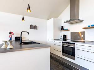 ボーゲンセにある4 person holiday home in Bogenseの白いキャビネットとシンク付きのキッチン