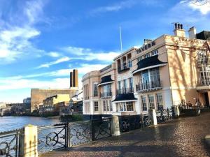 un edificio accanto a un fiume accanto a un edificio di Elegant & spacious parkside 2-bedroom 2-bathroom flat in period building opposite Blackheath Common - private entrance, great Greenwich location! a Londra