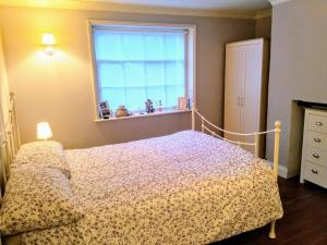 1 dormitorio con cama y ventana en Elegant & spacious parkside 2-bedroom 2-bathroom flat in period building opposite Blackheath Common - private entrance, great Greenwich location!, en Londres