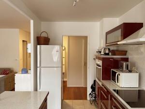 een keuken met een witte koelkast en een magnetron bij Appartement en plein cœur d'Aix-les-Bains in Aix-les-Bains
