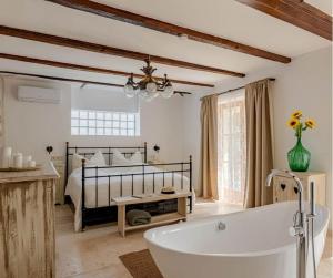 uma casa de banho com uma banheira ao lado de uma cama em Casa Elisabetta Apartmanház em Gárdony
