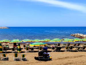 a group of chairs and umbrellas on a beach at Campeggio Bocca di Cecina in Marina di Cecina