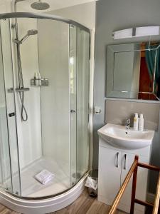 uma casa de banho com um chuveiro e um lavatório. em The Derby Arms Witherslack em Grange Over Sands